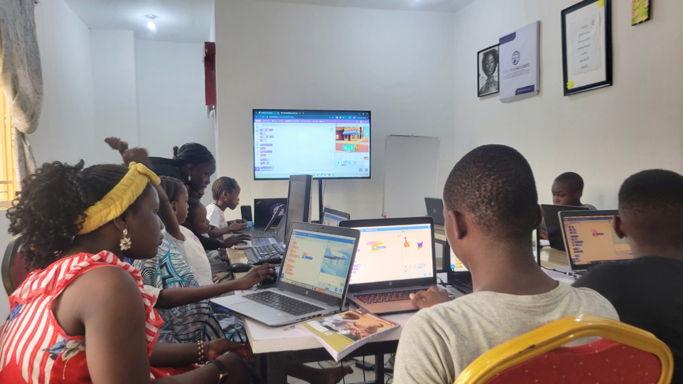 Kids working on coding projects at Toko Academy bootcamp session